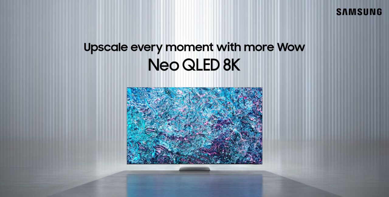 Telewizor Samsung Neo QLED 8K umieszczony w minimalistycznym wnętrzu z tekstami "Upscale every moment with more Wow" i logo Samsung w prawym górnym rogu.