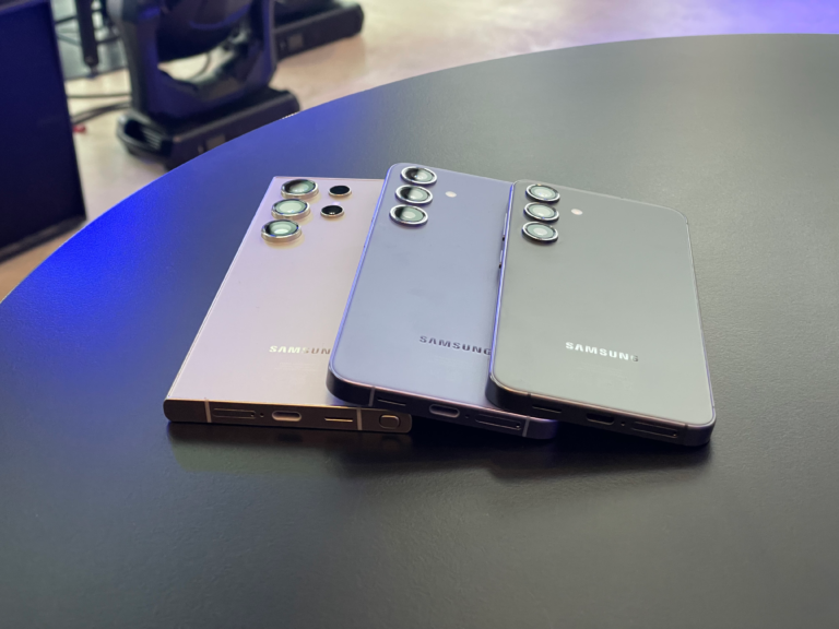 Trzy smartfony Samsung z serii Galaxy położone na czarnym stole.