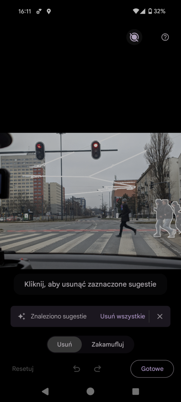 Osoba przechodząca przez pasy na sygnale czerwonym światła, widok z wnętrza samochodu, miejska zabudowa w tle, interfejs edycji zdjęć na pierwszym planie.