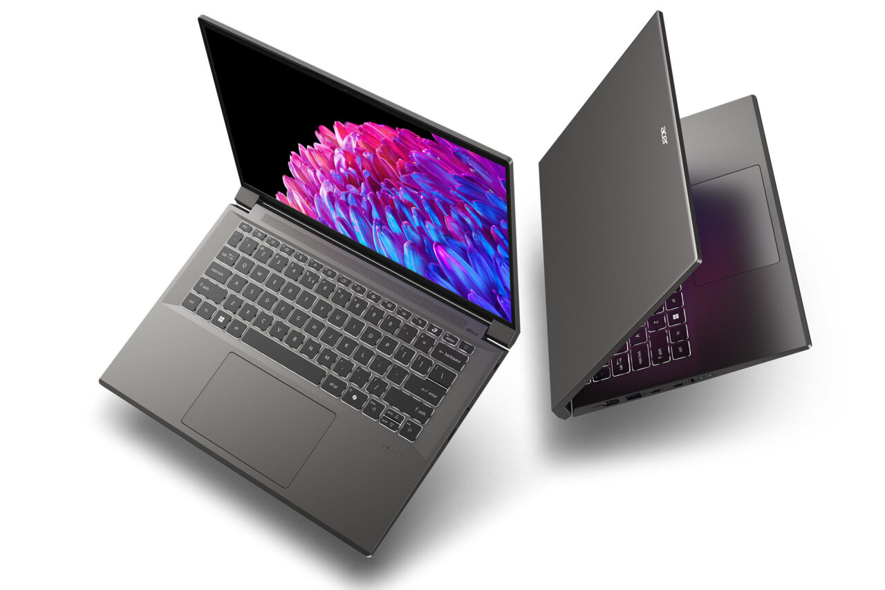 Dwa laptopy umieszczone jeden obok drugiego z otwartymi pokrywami; pierwszy z ekranem wyświetlającym kolorowy obraz, drugi odwrócony tyłem.