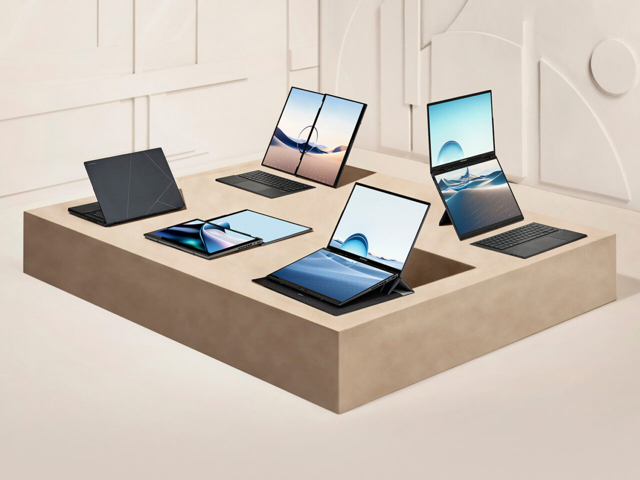 Kolekcja nowoczesnych laptopów Asus Zenbook Duo prezentowanych na stylowym, beżowym podium w minimalistycznie urządzonym wnętrzu.