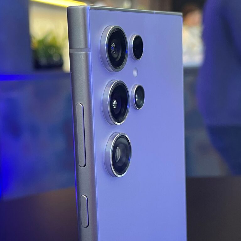 Zbliżenie na tylną stronę smartfona Samsung Galaxy S24 Ultra w kolorze jasnofioletowym z trzema obiektywami aparatu i przyciskami do regulacji głośności po lewej stronie.