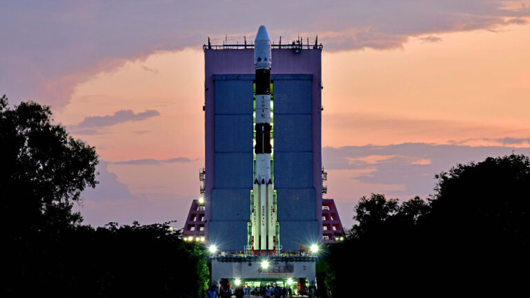 Rakieta nośna przygotowana przez Indie do startu na platformie startowej wieczorem, z widocznym różowym zabarwieniem nieba na tle.