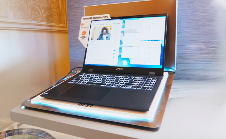 Laptop MSI na stojaku z podświetleniem, otwarty z widocznym ekranem pokazującym ustawienia kamery i inne interfejsy użytkownika.