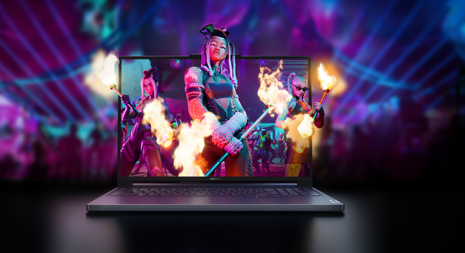 Laptop gamingowy Legion na przednim planie, wyświetlając kolorową grafikę z animowaną postacią trzymającą palącą się pałkę; w tle dynamiczne, rozmyte światła.