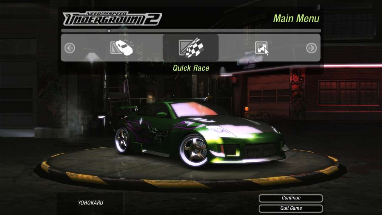 Zrzut ekranu z menu głównego gry Need for Speed Underground 2 przedstawiający zielony samochód sportowy z grafiką smoka po prawej stronie, stojący na obracającej się platformie z opcjami 'Quick Race', 'Continue' i 'Quit Game' do wyboru.