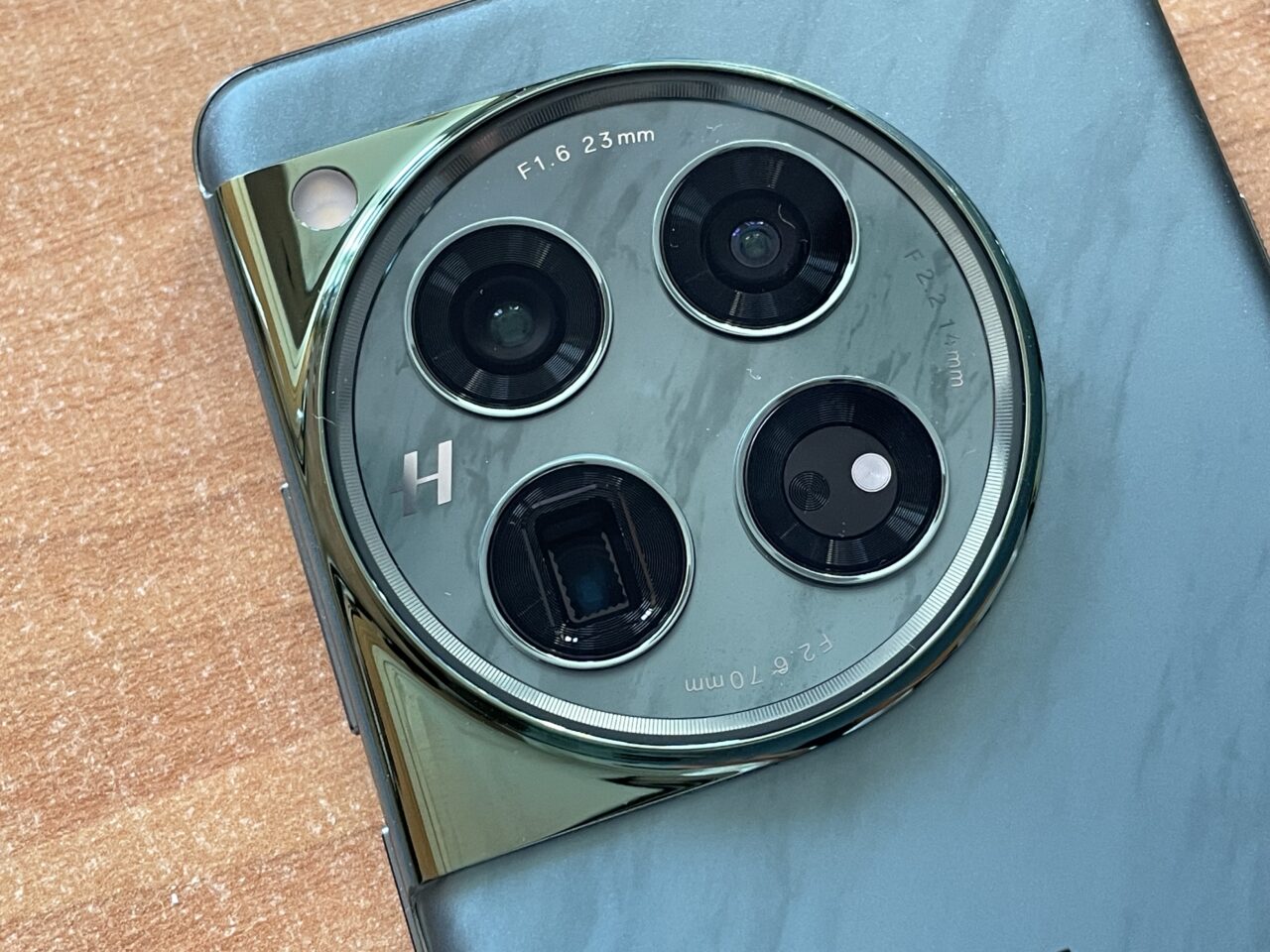 Smartphone verde com câmera com lente modular grande com diversas lentes e logotipo "H".