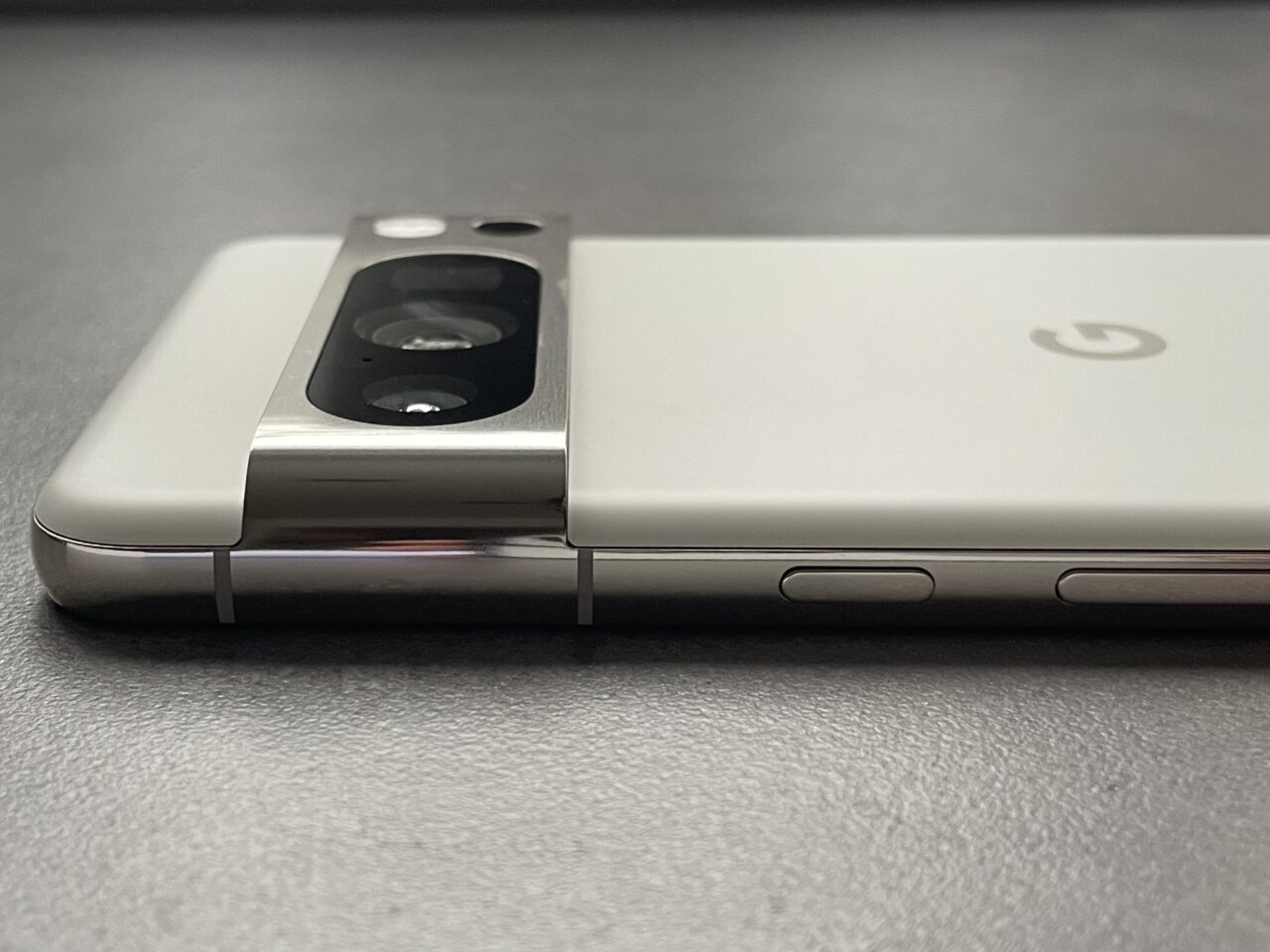 Zdjęcie zbliżenia tylnej części smartfona z wyeksponowanym blokiem aparatu i logotypem producenta.