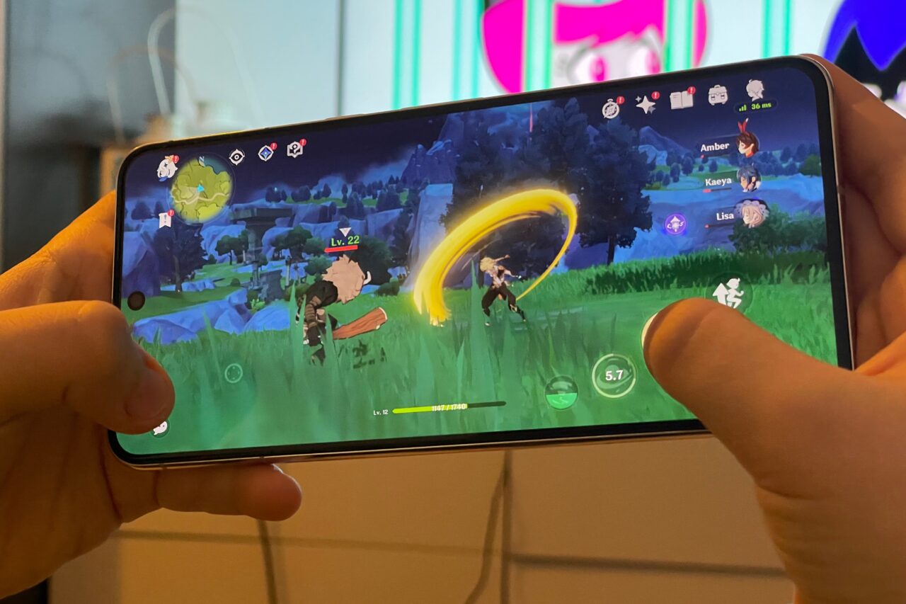 Osoba gra w mobilną grę RPG na ekranie smartfona, pokazując postać w świecie gry wykonującą atak.