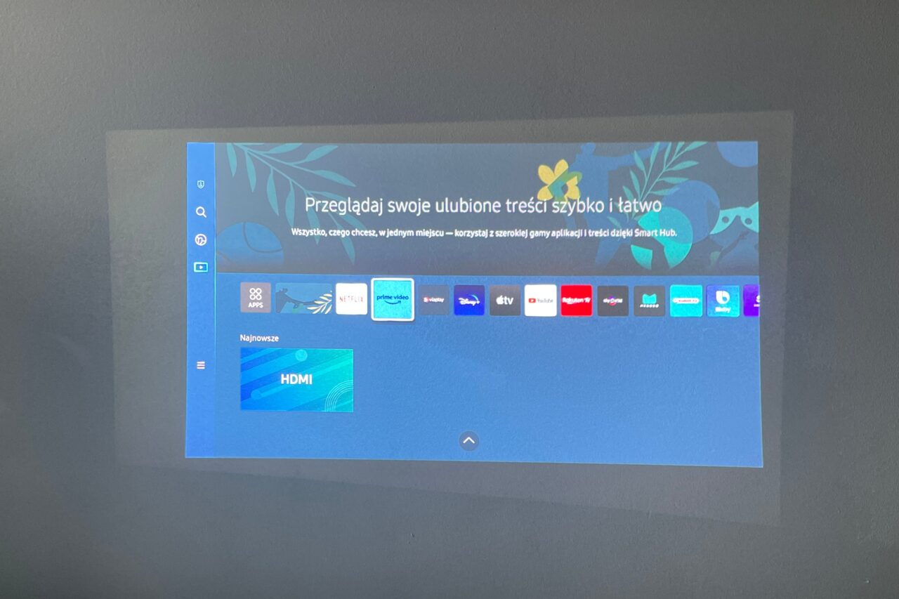 Ekran smart TV wyświetlający menu interfejsu użytkownika z aplikacjami streamingowymi takimi jak Netflix, Prime Video i YouTube.