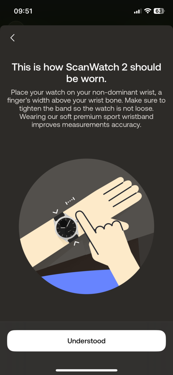 Ilustracja przedstawiająca poprawne noszenie zegarka ScanWatch 2 na nadgarstku, z zaleceniem umieszczenia go na niezdominowanej ręce, około szerokości palca powyżej kości nadgarstka, oraz dopasowania paska tak, aby zegarek nie był luźny.