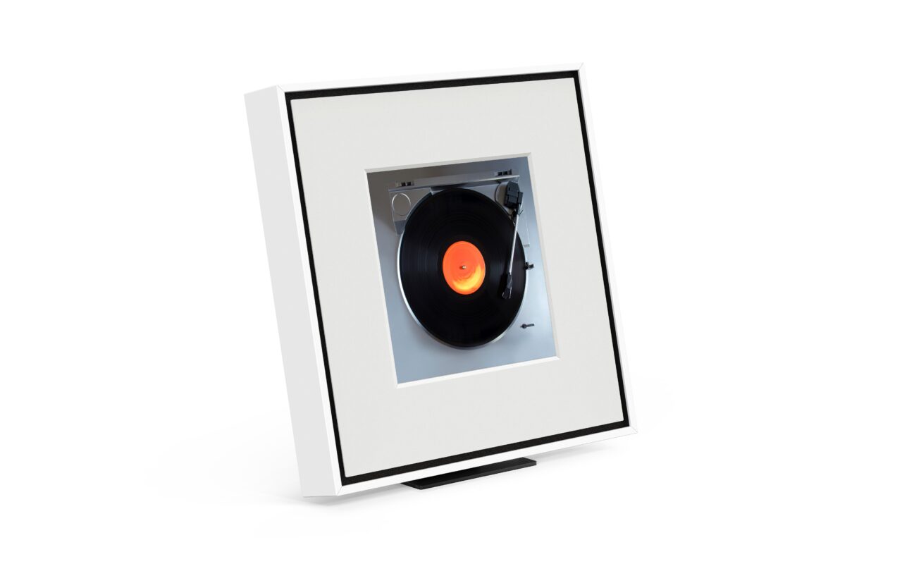 Obraz przedstawiający Samsung Music Frame, głośnik będący ramką na zdjęcia z wizerunkiem gramofonu i czarnej płyty winylowej.