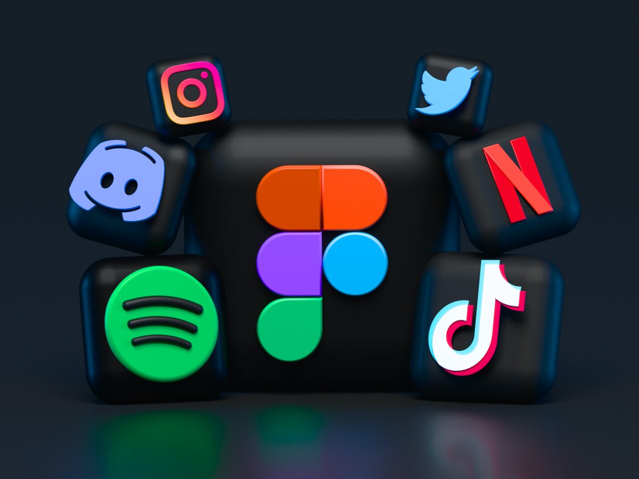 Ikony mediów społecznościowych i usług streamingowych unoszące się nad ciemnym tłem, wliczając Instagram, Twitter, Discord, Figma, Spotify, Netflix i TikTok.