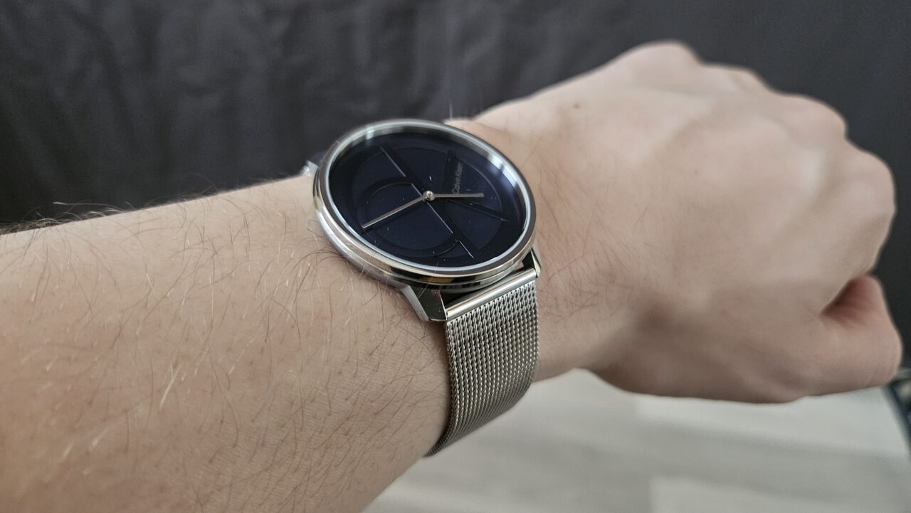 srebrny zegarek z niebieską tarczą na ręce