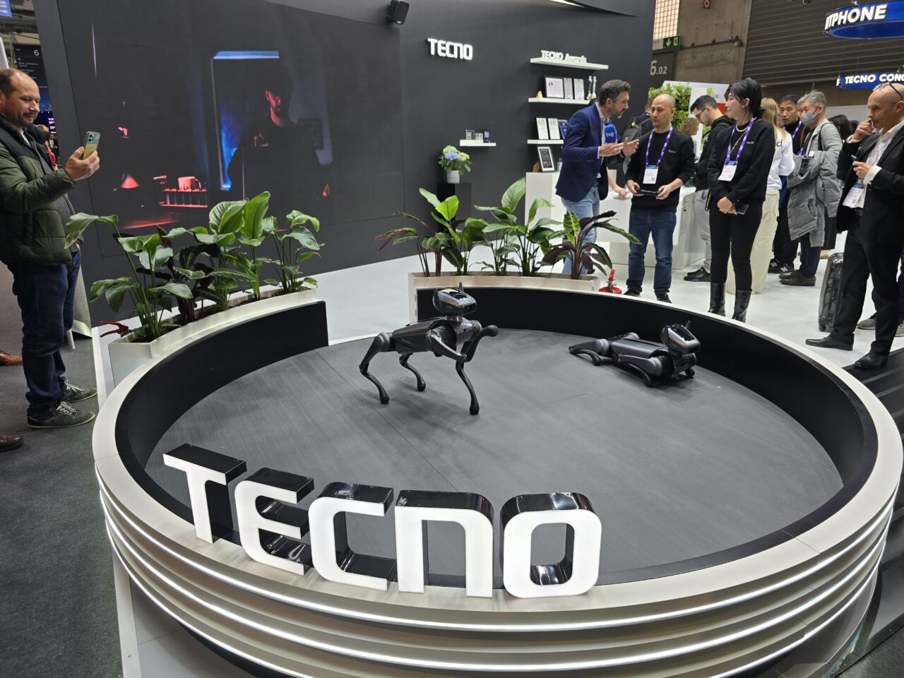 Robopies Tecno Dynamic 1. Stoisko firmy Techno z robotami czworonożnymi i grupą osób uczestniczących w pokazie technologicznym.