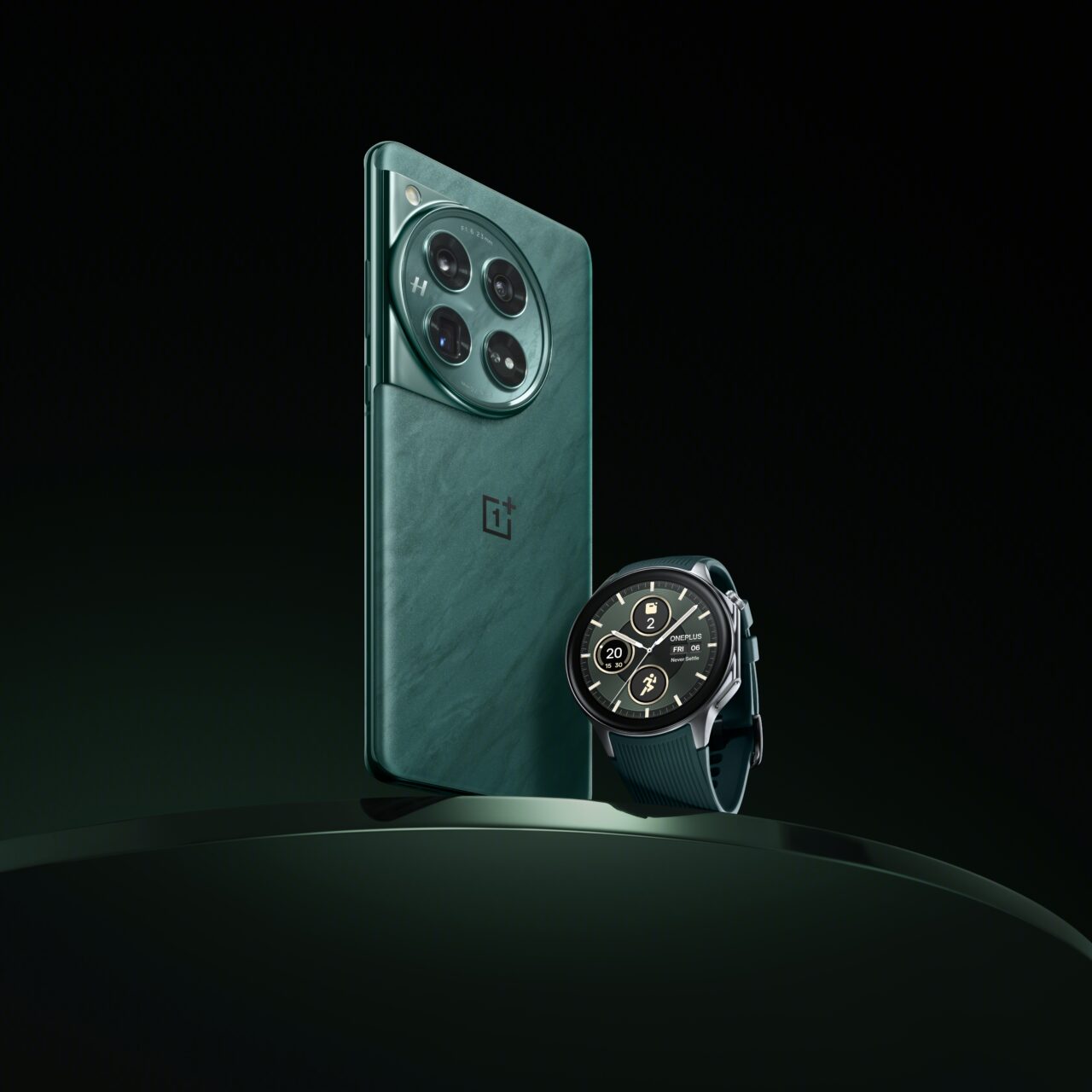 Smartfon marki OnePlus z potrójnym aparatem w zielonym etui stojący pionowo oraz czarny smartwatch z niebieskim paskiem na ciemnym tle.