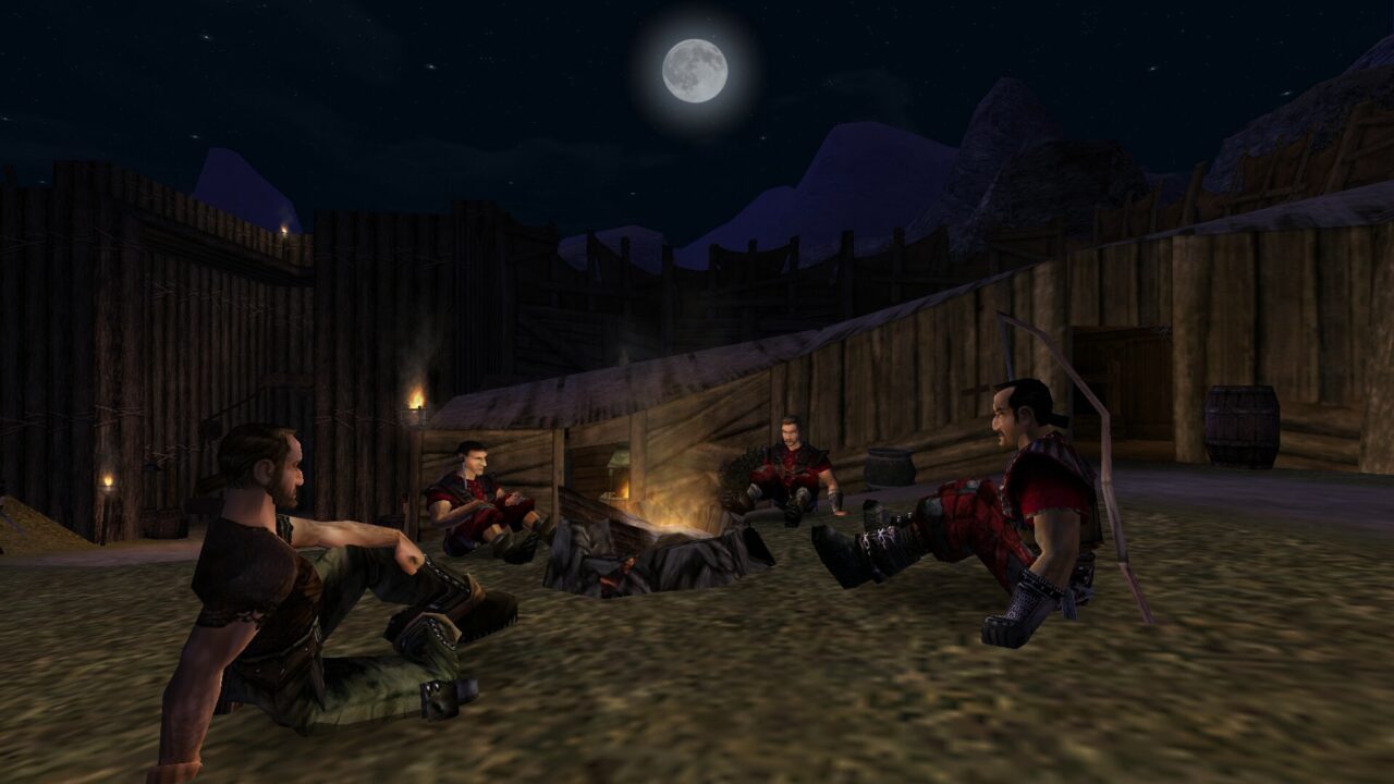 Czterech wojowników odpoczywa przy ognisku w nocy, w tle widać drewniane palisady i górski krajobraz pod księżycowym niebem.