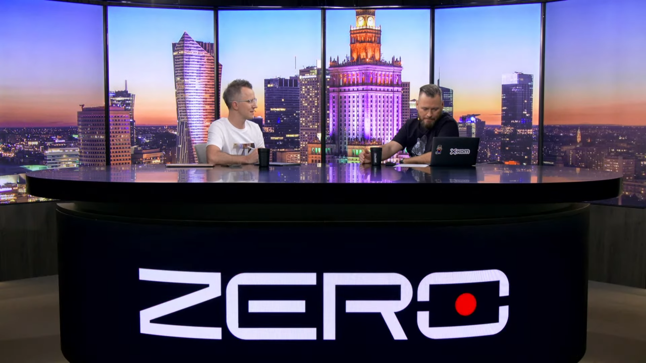 Kanał Zero. Dwóch mężczyzn siedzi przy biurku z napisem "ZERO" na tle panoramicznego widoku wieczornego miasta.