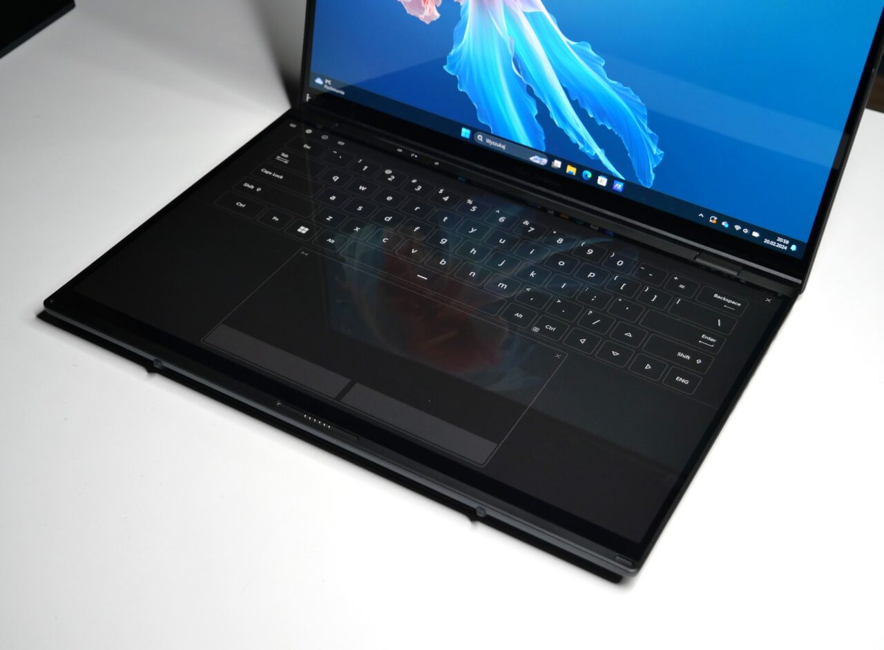 Otwarty laptop z klawiaturą i ekranem pokazującym grafikę wykonaną w stylu płomienia, umieszczony na białym tle.