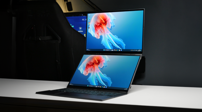 Laptop z dwoma ekranami umieszczony na białym biurku. Obydwa ekrany wyświetlają ten sam obraz - kolorową meduzę na niebieskim tle.