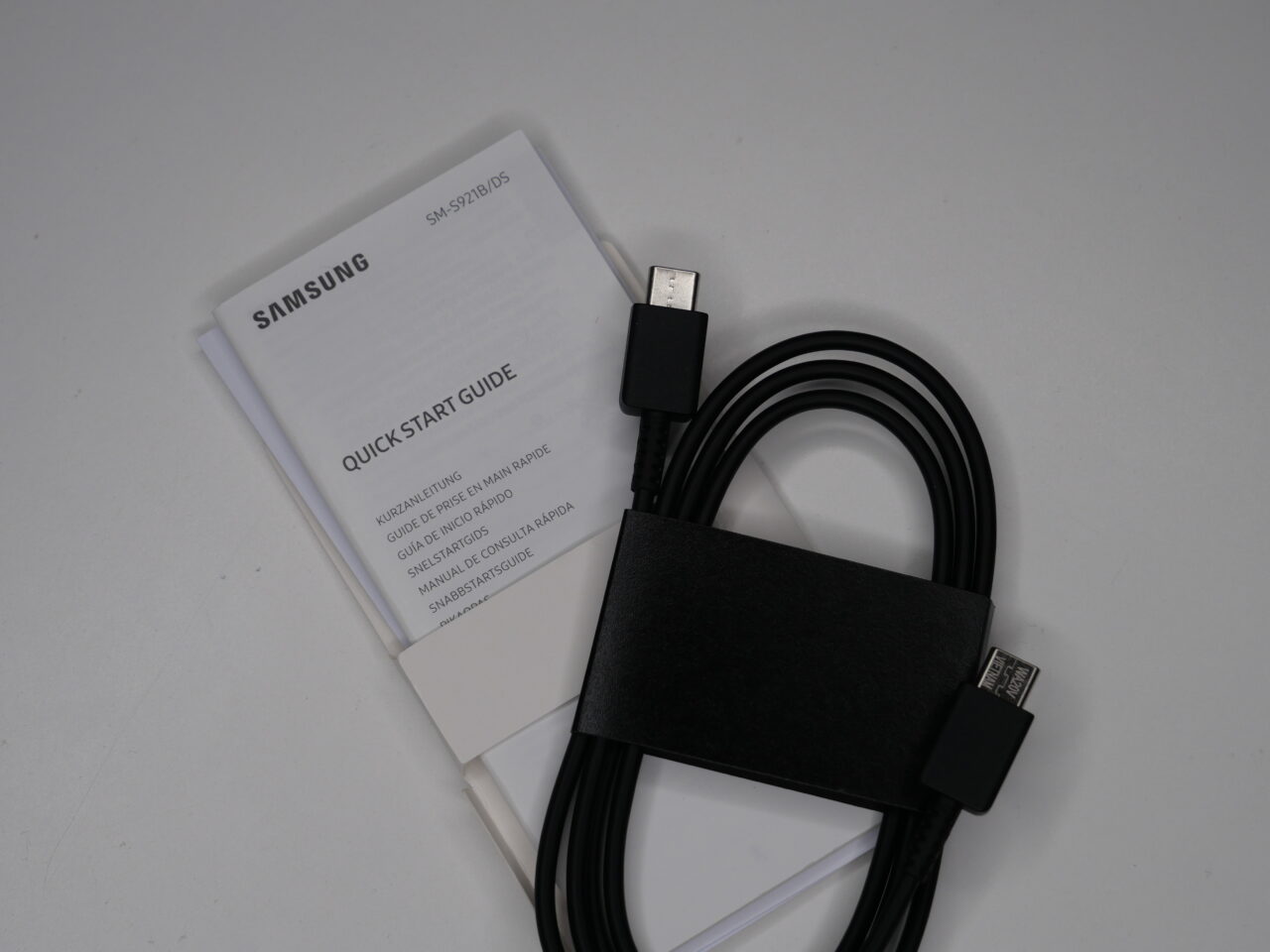 Czarny kabel USB z organizerem z czarnej skóry i skrócona instrukcja obsługi Samsung.