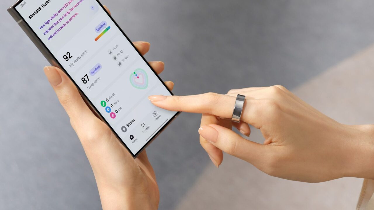 Dłonie trzymające smartfon, na którego ekranie wyświetlana jest aplikacja zdrowotna z danymi takimi jak wynik tętna i jakość snu.