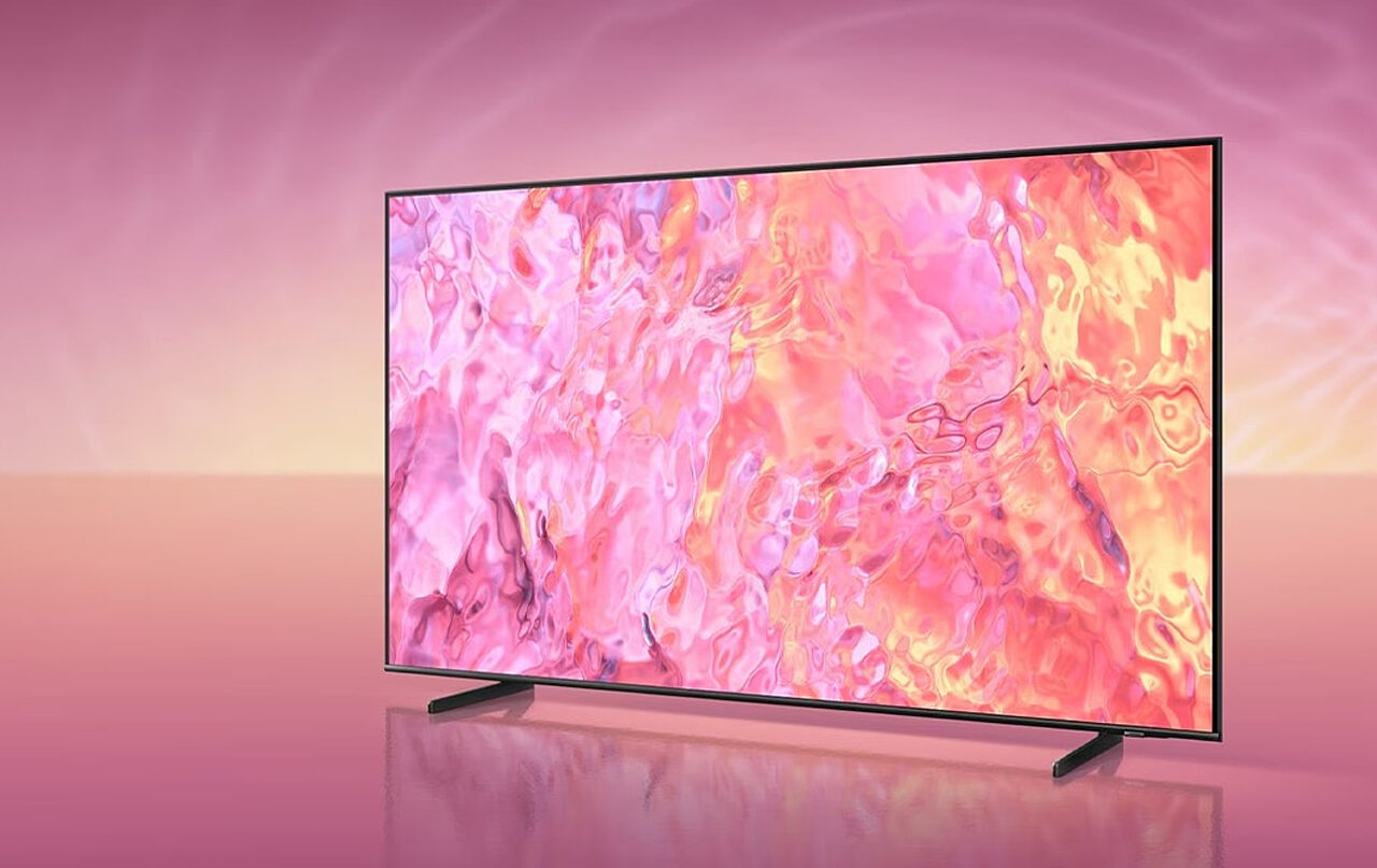 Telewizory Samsunga QLED w nowej promocji. Odbiornik na tle o różowych odcieniach wyświetlający dynamiczne abstrakcyjne grafiki w różowym i pomarańczowym kolorze.
