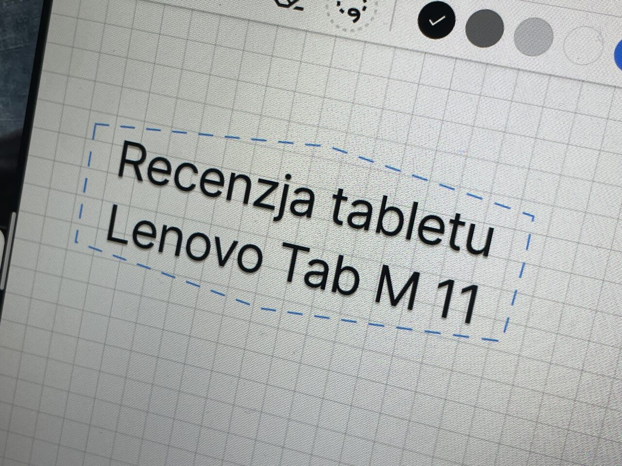 Zrzut ekranu z tekstem "Recenzja tabletu Lenovo Tab M 11" wyświetlony na ekranie urządzenia z zaznaczonym tekstem przerywaną linią.