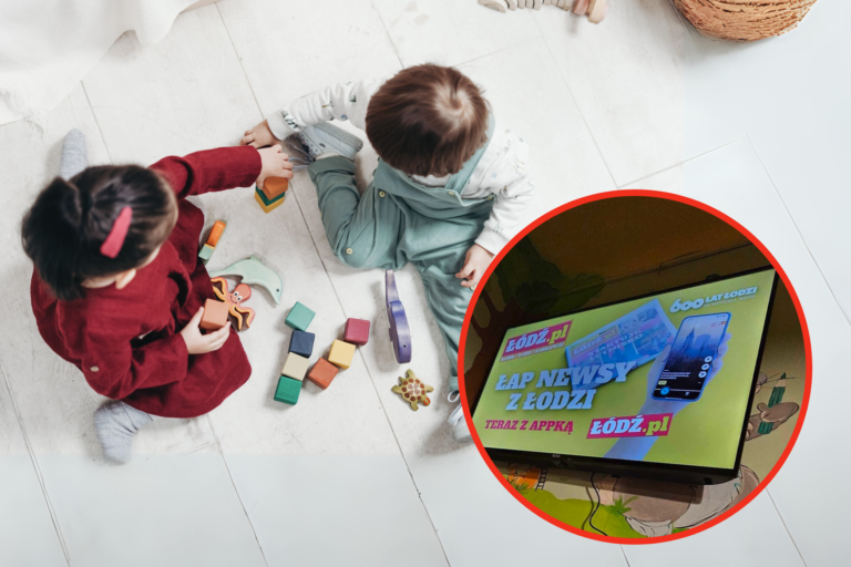 Dwójka dzieci siedzących na podłodze bawi się klockami, w tle stoi telewizor wyświetlający stronę internetową z napisem "EAP NEWSY Z ŁODZI".