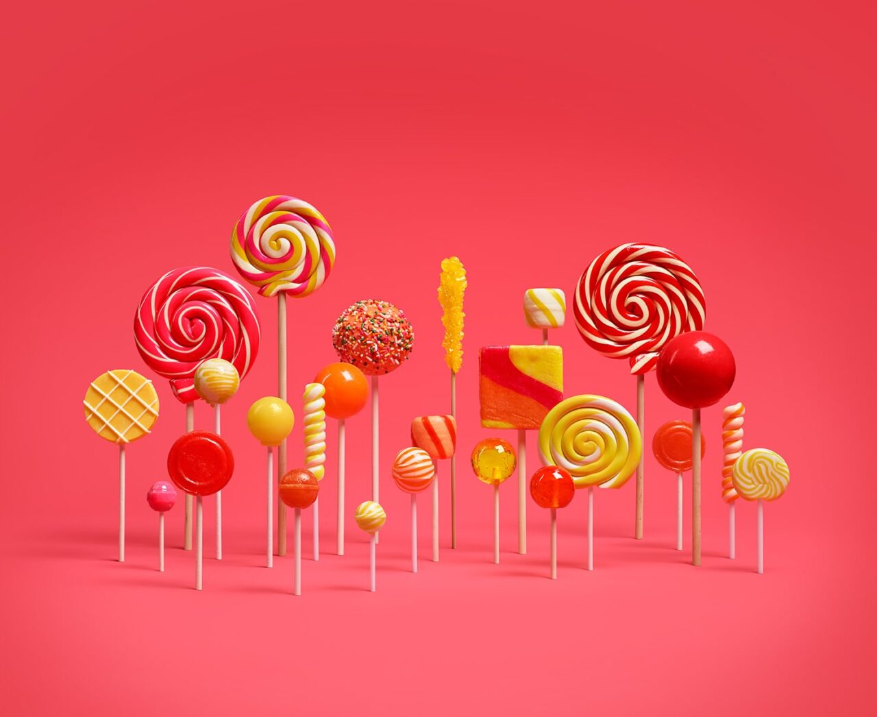 Kolorowe lizaki i cukierki różnych rozmiarów i kształtów ustawione na czerwonym tle.
