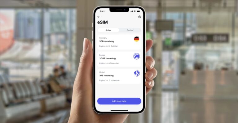 Ręka trzymająca smartfon z otwartą aplikacją eSIM pokazującą dostępne pakiety danych dla Niemiec, Europy i globalne, w tle rozmazane lotnisko.