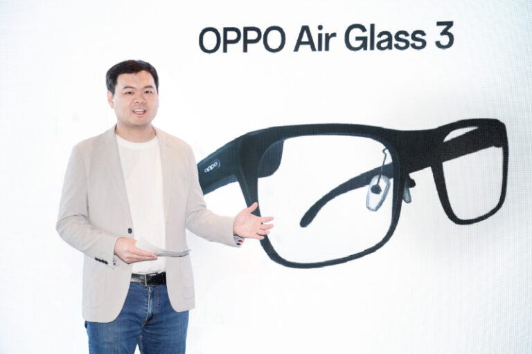 Mężczyzna w jasnym garniturze prezentujący model okularów "OPPO Air Glass 3" na tle z grafiką dużych okularów.