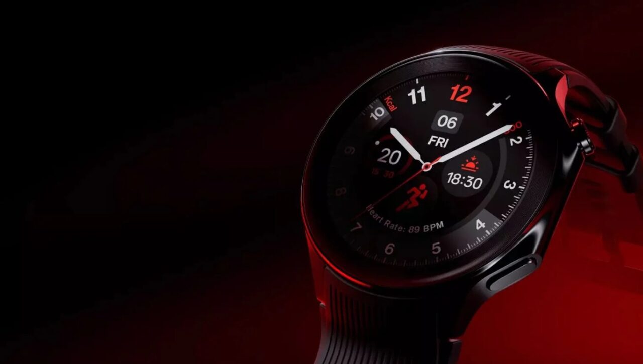 Zegarek inteligentny na czarnym pasku, z czerwonym refleksem światła na tarczy i obudowie. Tarcza wyświetla czas, datę, tętno i spalone kalorie na ciemnym tle.