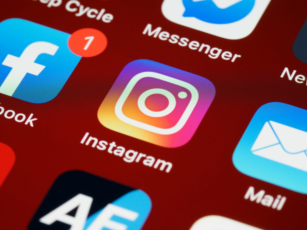 Media społecznościowe. Zbliżenie na ikonę aplikacji Instagram na ekranie smartfona z widocznymi ikonami innych aplikacji, takimi jak Facebook i Messenger w tle.