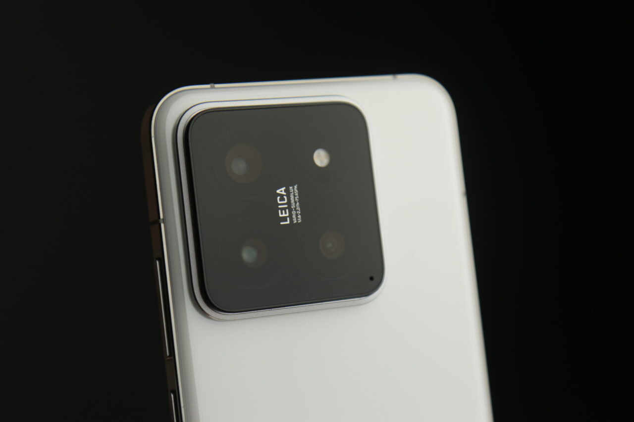 Aparat fotograficzny Xiaomi 14 z logo Leica na białym tle z czarnym tłem w tle.