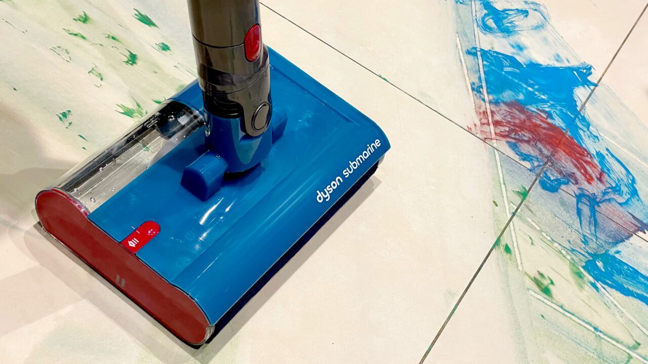 Odkurzacz bezprzewodowy marki Dyson na podłodze, obok widoczne ślady malowania farbami.