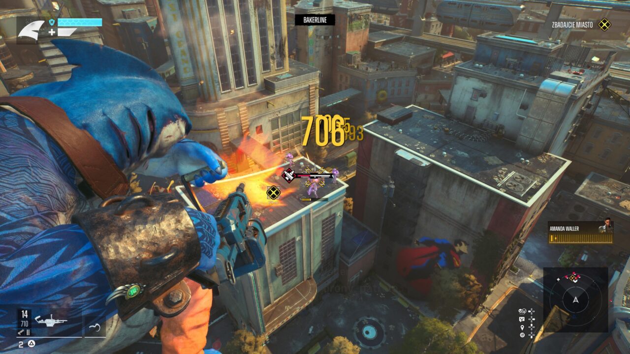 Widok z góry na miejską scenę z gry wideo Suicide Squad: Kill the Justice League, gdzie postać w niebieskim kostiumie superbohatera przelatuje nad budynkiem, a na ekranie pojawiają się elementy interfejsu użytkownika, w tym zdrowie, amunicja i punktacja.