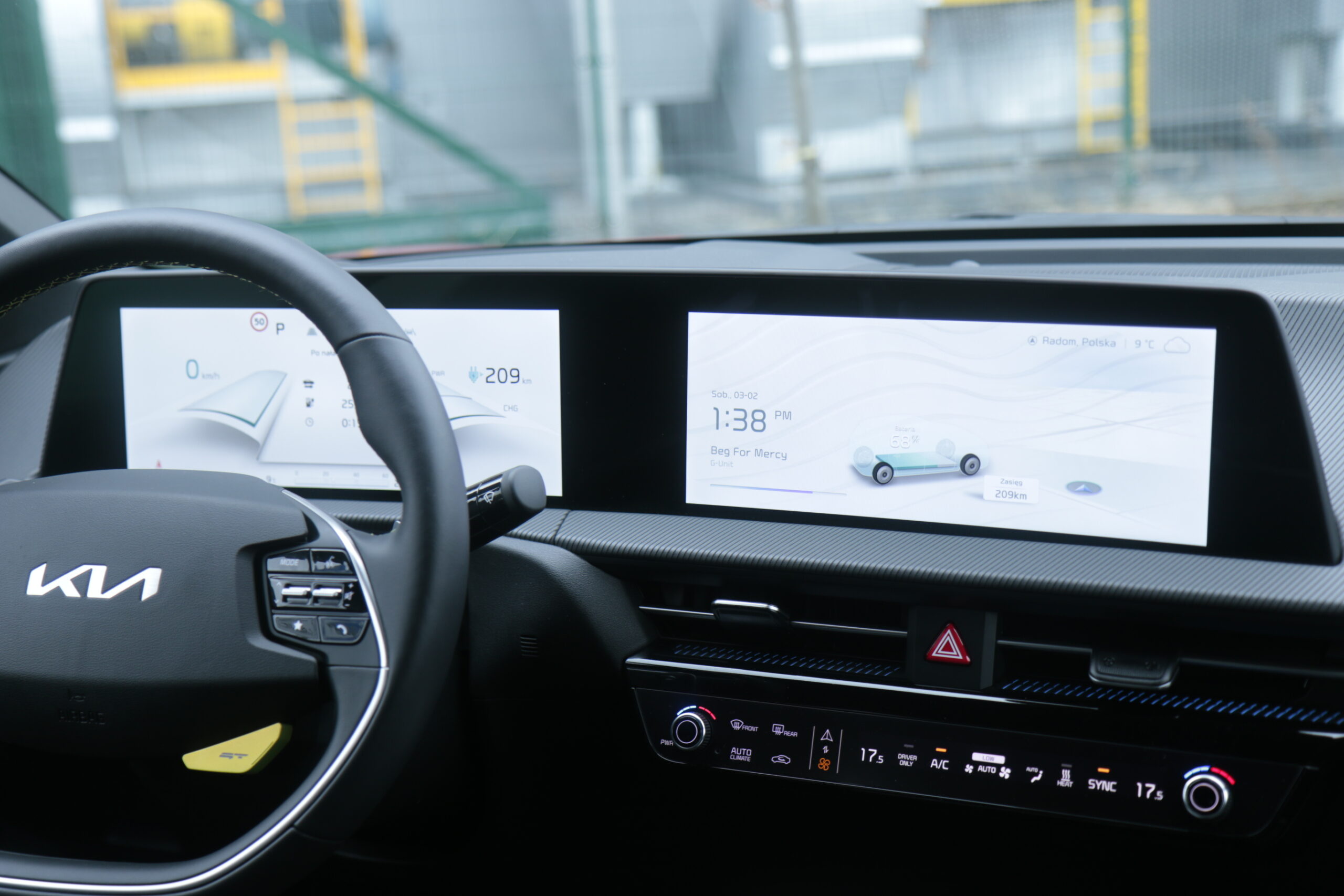 Wnętrze samochodu marki Kia EV6 GT z widokiem na kierownicę i deski rozdzielczej wyświetlającej ekran z prędkościomierzem i nawigacją.