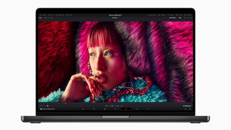 Zdjęcie na wyświetlaczu laptopa przedstawia kolorowy portret młodej kobiety z różowymi włosami i biżuterią, z programem do edycji wideo DaVinci Resolve w tle.