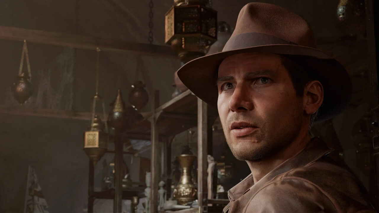 Kadr z gry Indiana Jones i wielki krąg do artykułu pt. Indiana Jones na konsolach. Mężczyzna w brązowym kapeluszu i kurtce patrzy z zamyśleniem, w tle widoczne są egzotyczne przedmioty.