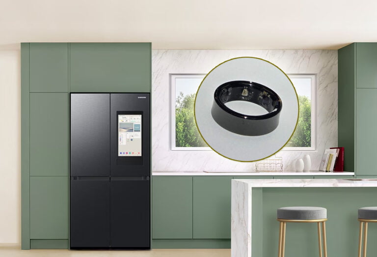Nowoczesna kuchnia z zielonymi szafkami, czarnym inteligentnym lodówko-zamrażarką Samsung, marmurowym blatem i wyspą kuchenną z dwoma szarymi stołkami barowymi; w tle widok przez okno na zielone drzewa; nad wyspą kuchenną znajduje się okrągłe, powiększone zdjęcie czarnego inteligentnego pierścienia.