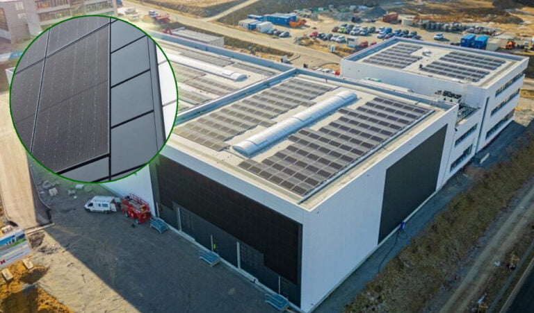 Widok z lotu ptaka na nowoczesny budynek przemysłowy z panelemi słonecznymi na dachu, w powiększeniu fragment solarnej instalacji.