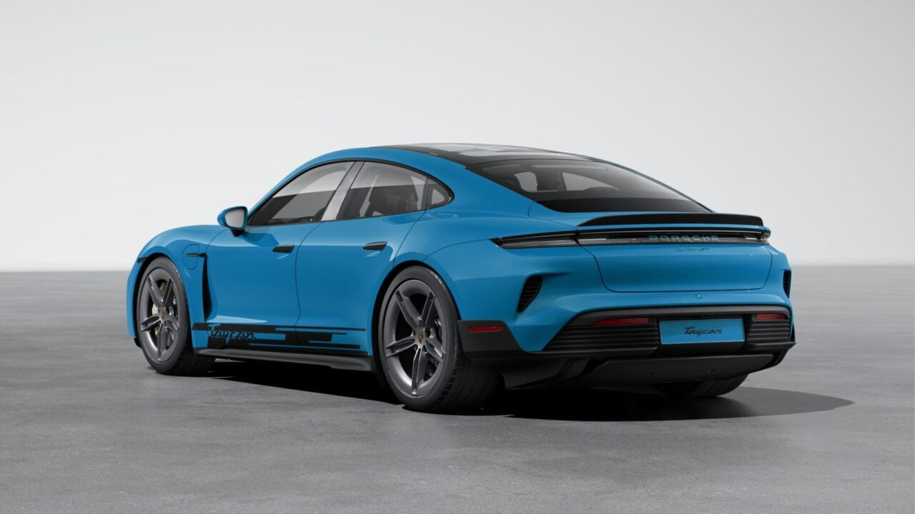 Konfigurator Porsche. Niebieskie sportowe coupé Porsche Taycan na tle jednolitej szarej powierzchni.