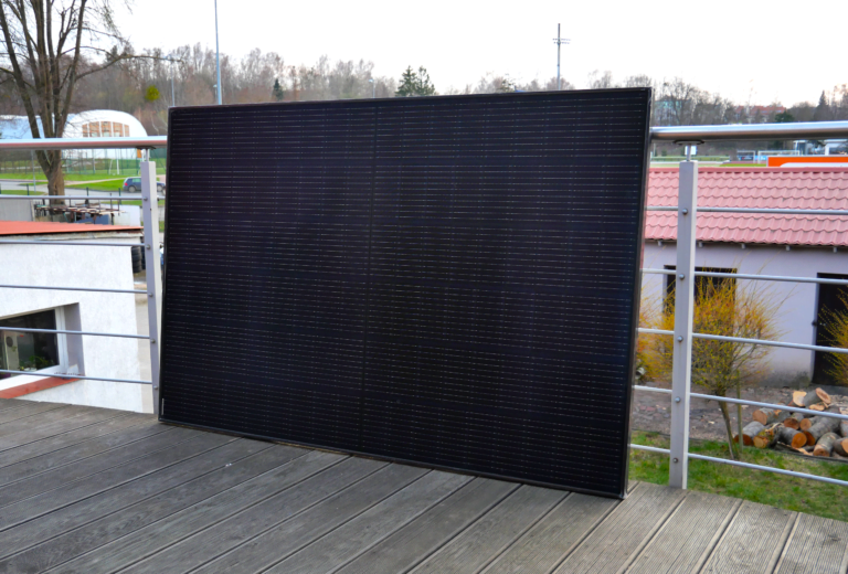 Panel solarny z zestawu fotowoltaiki balkonowej EcoFlow Classic Plus Delta 2 oparty o barierkę tarasu.