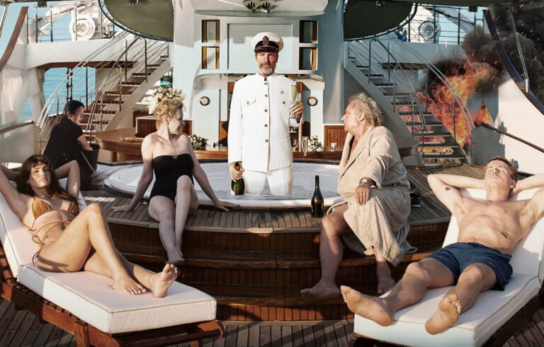 Plakat filmu W trójkącie. Opis obrazu: Grupa ludzi relaksująca się na pokładzie luksusowego jachtu, w tym mężczyzna w mundurze kapitańskim z szampanem, kobiety opalające się i mężczyzna leżący na leżaku, z ogniem i dymem widocznym w tle na schodach jachtu.