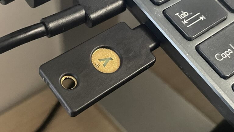 Czarny adapter USB z logo w kształcie błyskawicy położony na klawiaturze komputera.