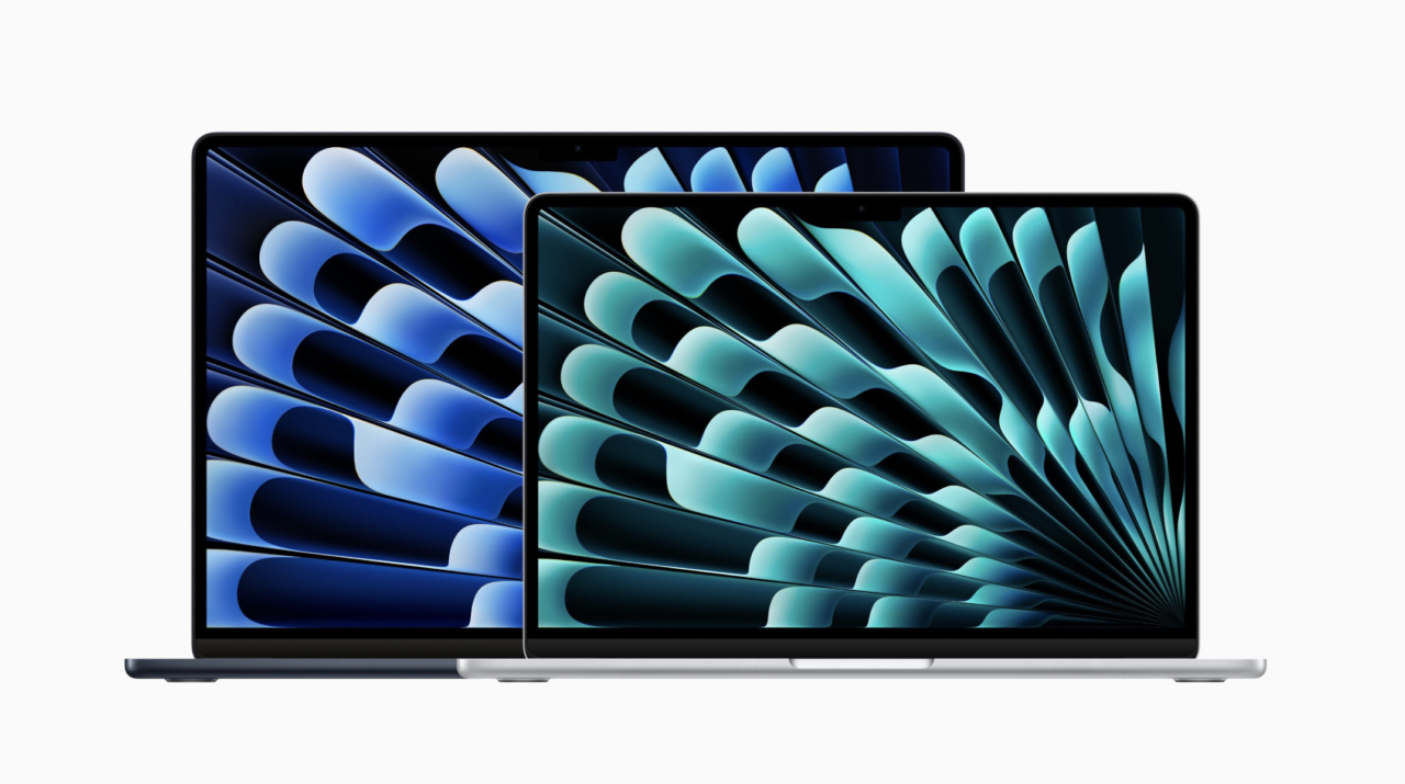 Dois laptops abertos com bordas pretas e fundos abstratos em azul claro nas telas, colocados um atrás do outro.