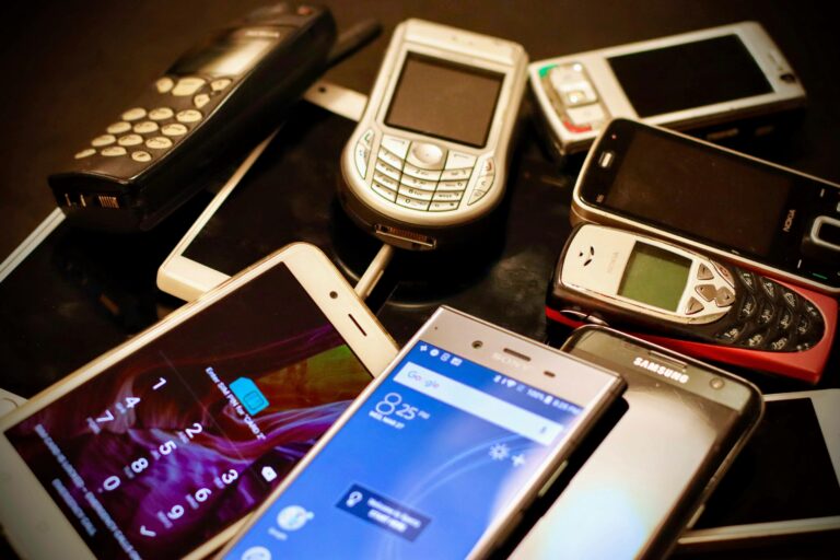 Zbiór różnych modeli telefonów komórkowych z różnych okresów, w tym klasyczne telefony z klawiaturą i nowoczesne smartfony.