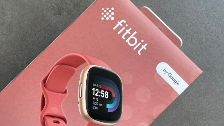 Opakowanie smartwatcha Fitbit w kolorze różowym z wyświetlaczem pokazującym godzinę 12:58, tętno, czas spędzony aktywnie i liczbę spalonych kalorii, oraz oznaczeniem "by Google".
