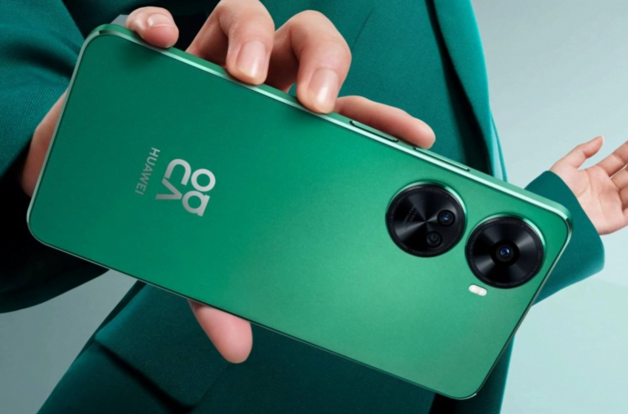 Zielony telefon komórkowy marki Huawei trzymany w ręku na tle zielonego ubrania, z widocznym logo producenta i podwójnym aparatem z tyłu.